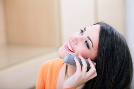 Closeup portrait of a happy woman on phone at home looking at copyspaceの写真素材