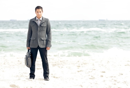 Young businessman standing on the beachの写真素材