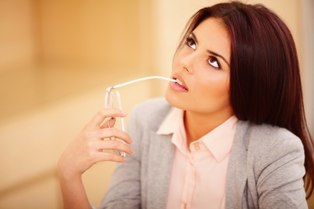Young pensive casual businesswoman with glasses looking upの写真素材