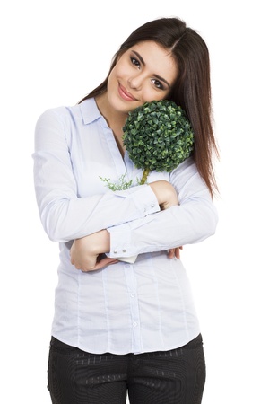 Young beautiful woman hugging small green treeの写真素材