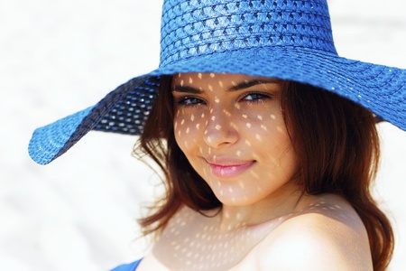 Closeup portrait of a teen girl resting on the beach in hatの写真素材