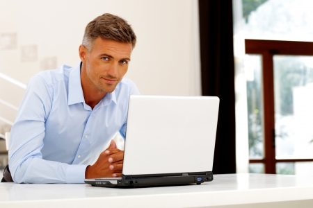 Mature happy businessman working with laptopの写真素材