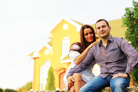 Happy couple sitting in the garden in front of new homeの写真素材