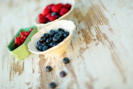 Mix of blueberries, strawberries and currant in vintage platesの写真素材