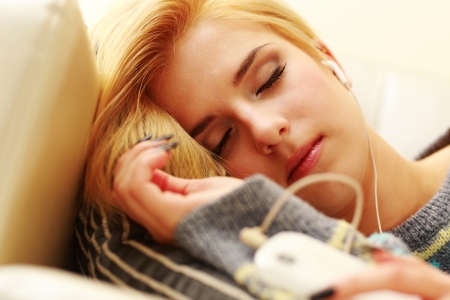 Young sleeping woman listening music の写真素材