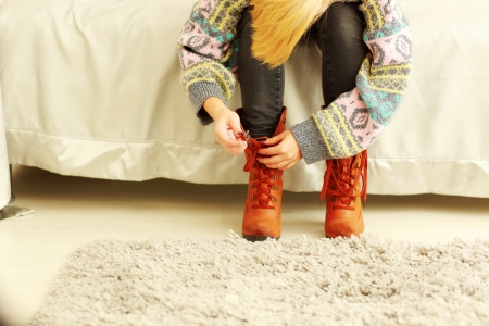 Woman taking off her boots at homeの写真素材