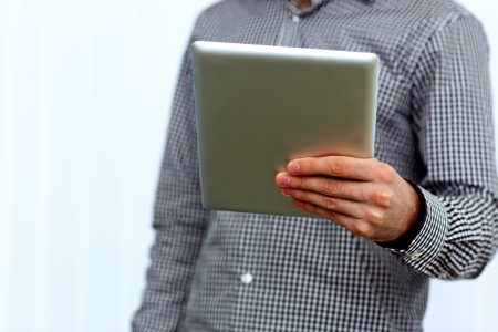 Closeup image of male hand holding tablet computer 