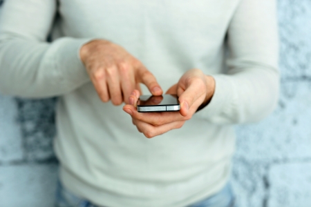 Closeup image of a male hand holding smartphone 