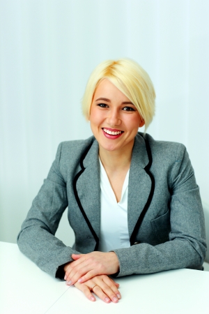 portrait of a young happy businesswoman sitting at the table in officeの写真素材
