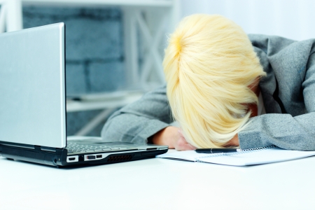 Businesswoman sleeping on her workplace in officeの写真素材