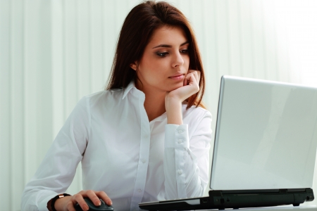 Young businesswoman in headphones working on a laptop at officeの写真素材