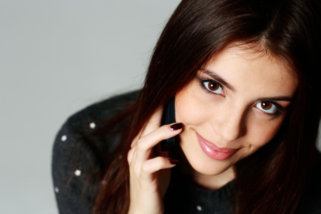 Closeup portrait of a young happy woman talking on the phoneの写真素材