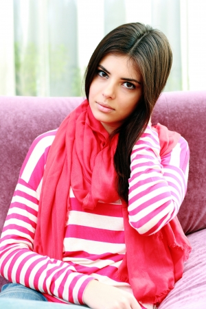 Young thoughtful woman touching her hair at homeの写真素材