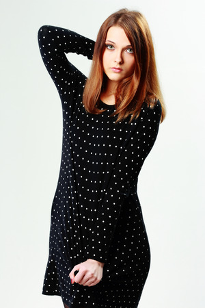 Portrait of a young pensive woman standing on gray の写真素材