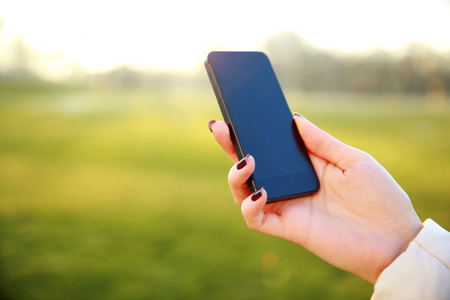 Closeup image of a female hand holding smartphoneの写真素材