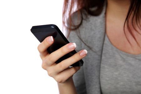 Closeup image of a female hands holding smartphone isolated on white backgroundの写真素材