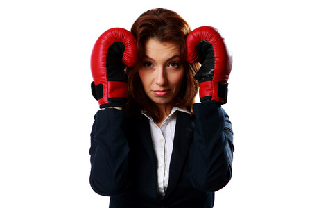 Businesswoman wearing boxing gloves standing in protective pose, isolated on a white backgroundの写真素材