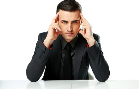 Confident businessman sitting at the table isolated on a white backgroundの写真素材
