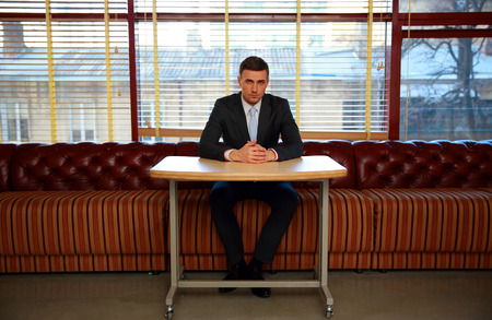 Confident businessman sitting at the table in officeの写真素材