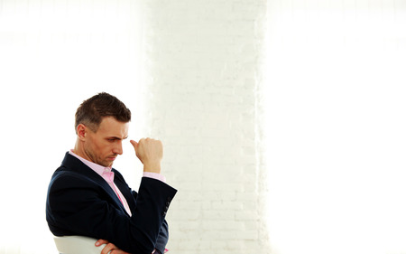 Pensive businessman sitting on the office chairの写真素材