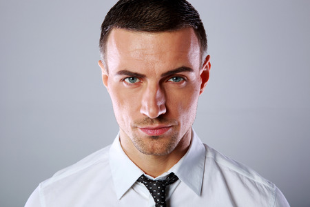 Portrait of a confident businessman over gray backgroundの写真素材