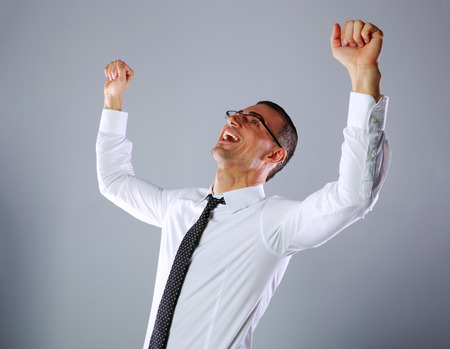 Portrait of a excited businessman on gray backgroundの写真素材