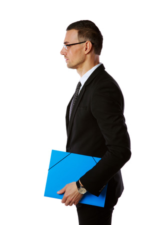 Side view portrait of a businessman in glasses with blue folder over white backgroundの写真素材