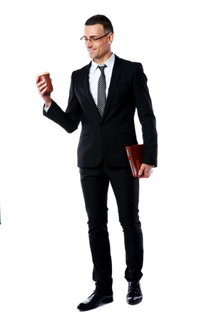 Full-length portrait of a businessman holding cup of coffee and tablet computer over white backgroundの写真素材