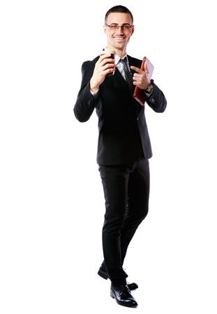 Full-length portrait of a businessman holding cup of coffee and tablet computer over white backgroundの写真素材