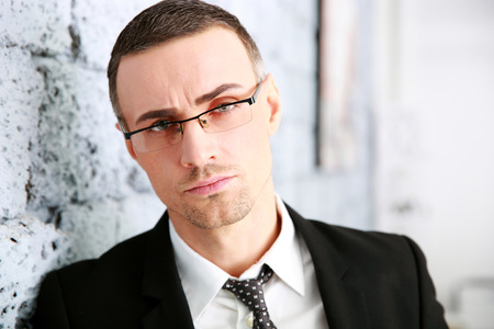 Confident businessman standing near brick wallの写真素材