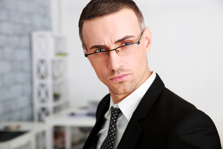Portrait of a confident businessman in glasses at officeの写真素材