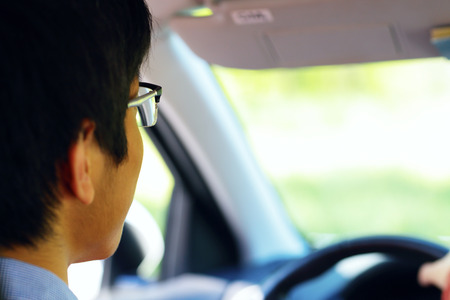 Closeup portrait of a driver is sitting in his car and is drivingの写真素材
