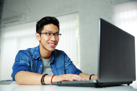Happy young asian man working at office