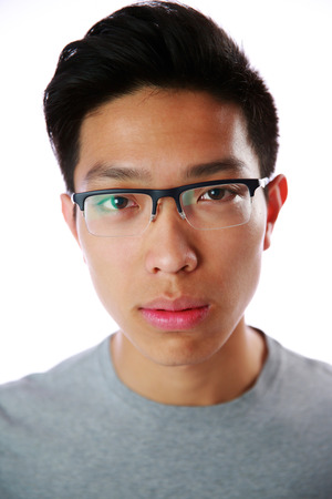 Closeup portrait of a young serious asian man over white backgroundの写真素材