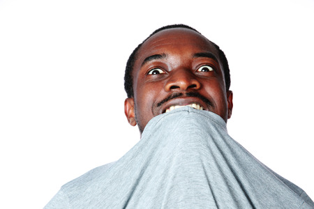Portrait of crazy young african man biting his t-shirt over white backgroundの写真素材