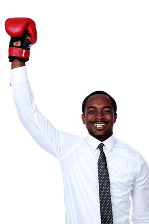 Businessman with boxing gloves raised his hand over white backgroundの写真素材