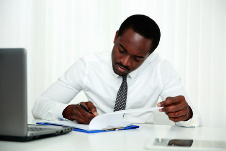 African man signing document in officeの写真素材