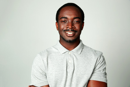 Portrait of a smiling african man on grya backgroundの写真素材