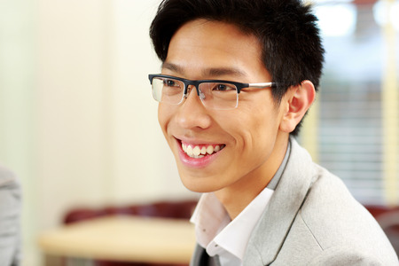 Portrait of a cheerful businessman in glasses at officeの写真素材