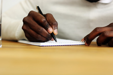 Closeup portrait of a male hand writing on a paperの写真素材