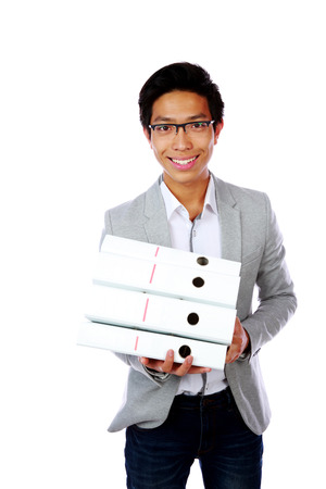 Cheerful asian man with folders standing over white backgroundの写真素材