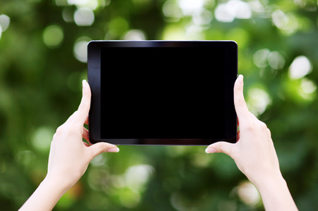 Closeup portrait of a female hands holding tablet computer with blank screenの写真素材