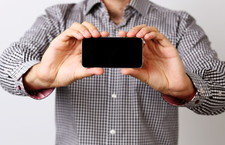 Closeup portrait of a male hands holding smartphoneの写真素材