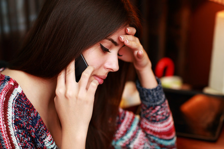Closeup portrait of a beautiful woman talking on the phoneの写真素材