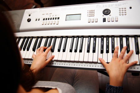 Female piano player, view from the top, body and buttons of the piano were digitally modified