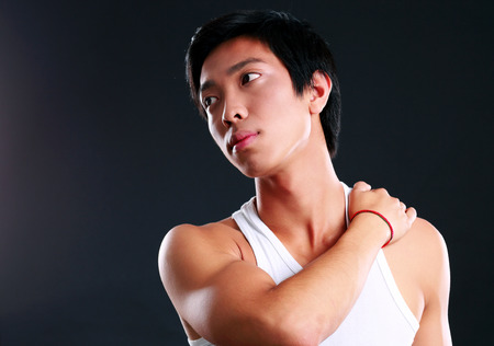 Portrait of a pensive muscular man on black backgroundの写真素材