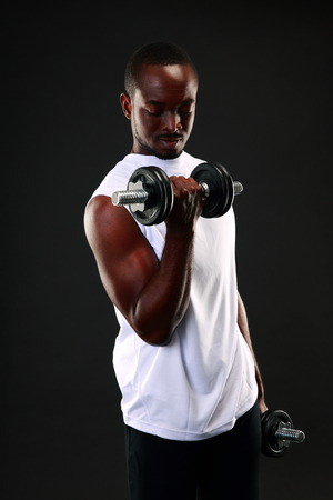 Portrait of african man working out with dumbbellsの写真素材