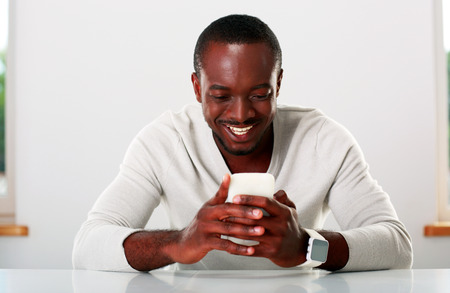 Portrait of a smiling african man using smartphoneの写真素材