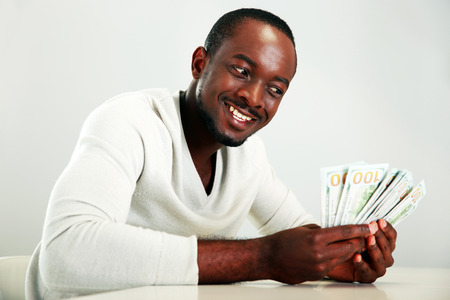 Portrait of a smiling african man holding US dollars