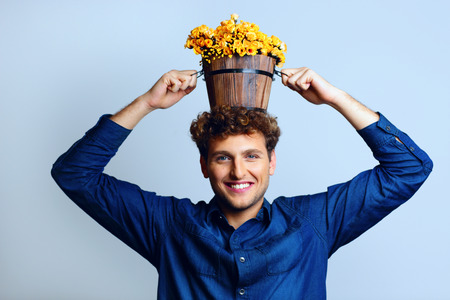 Smiling man with a bucket on his head with flowersの写真素材